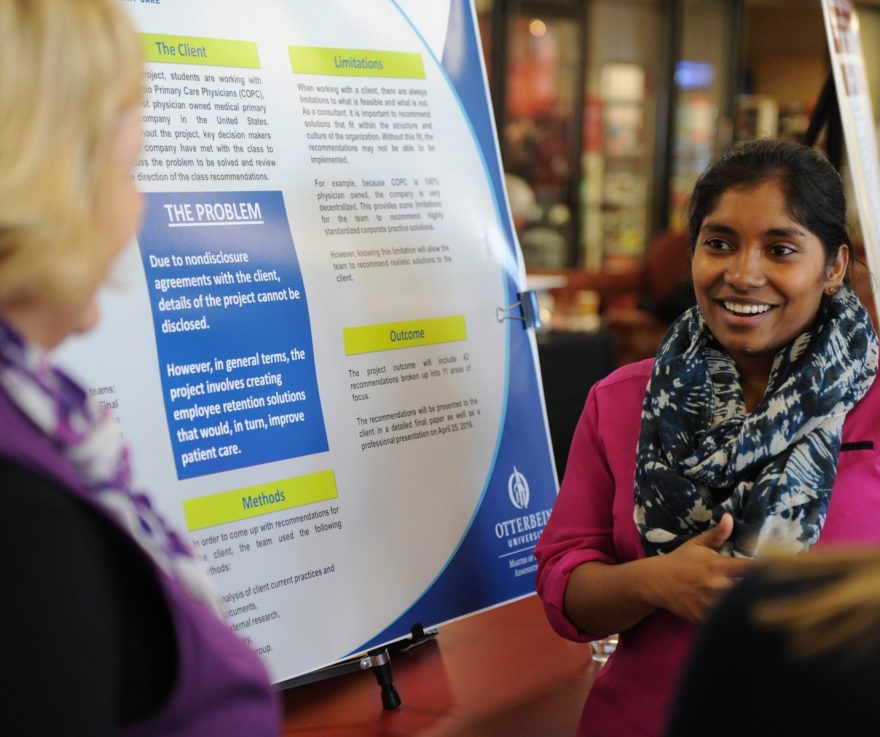 An ǿմý graduate student presents a poster at a conference.